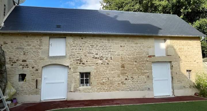 Bâtiment en pierre rénové avec une toiture en ardoise moderne Argentan