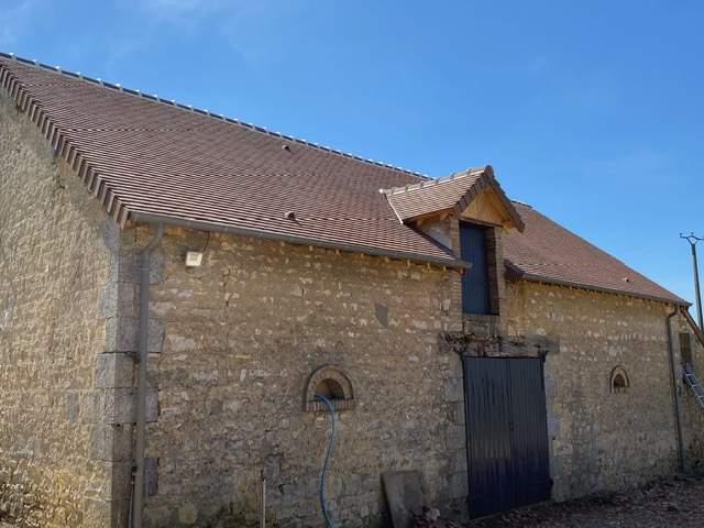 Façade en pierre épaisse et toiture neuve en tuiles rouges Argentan