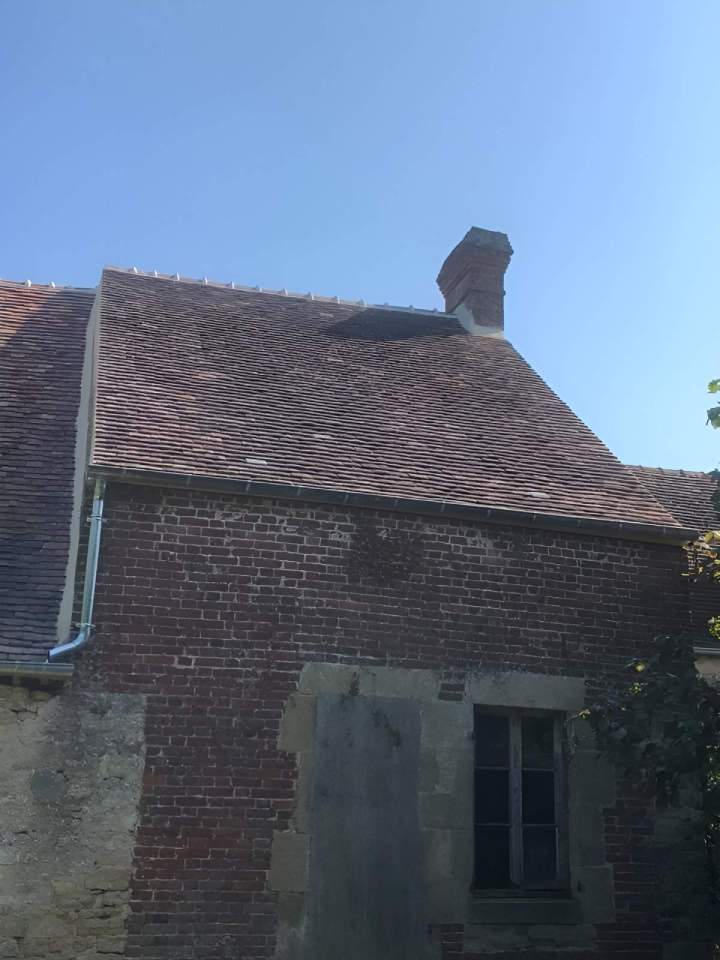 Vieille bâtisse ave gouttière et toiture pente en tuiles rouges Argentan